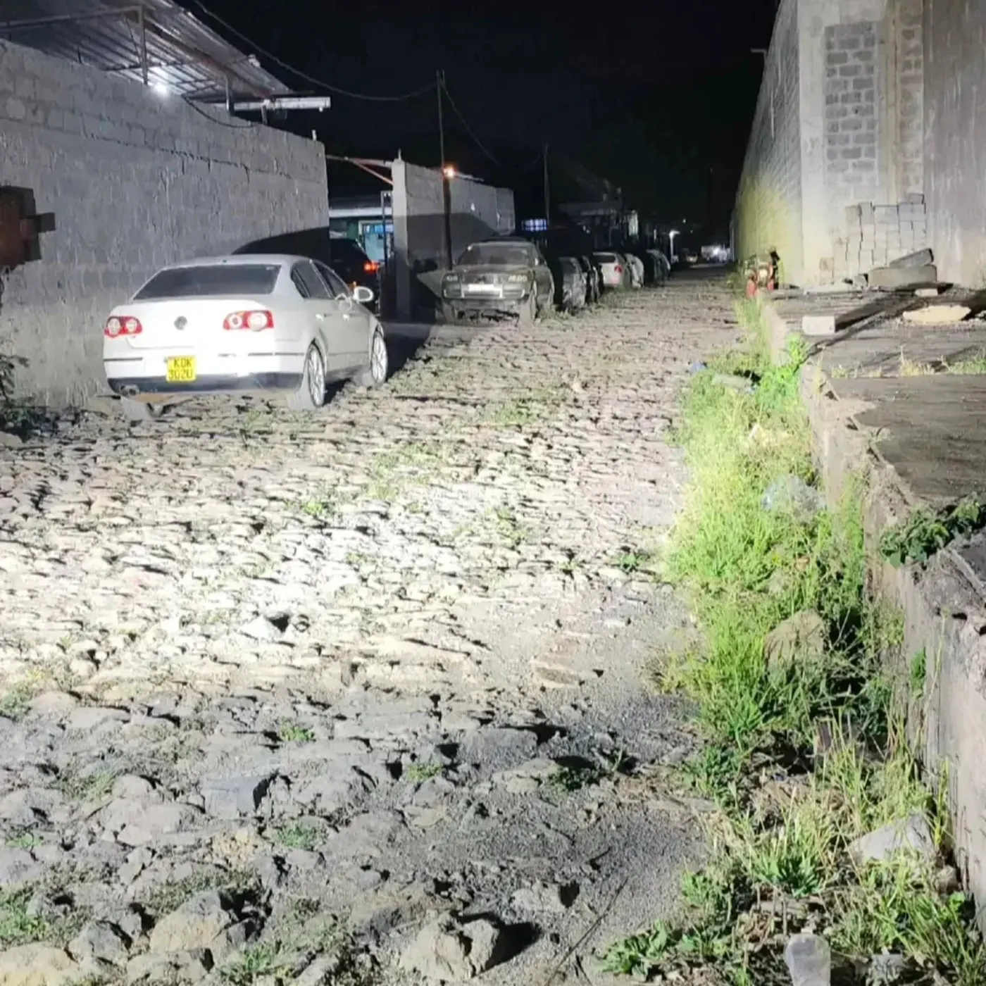 Projector headlight beam lighting a rough road at night