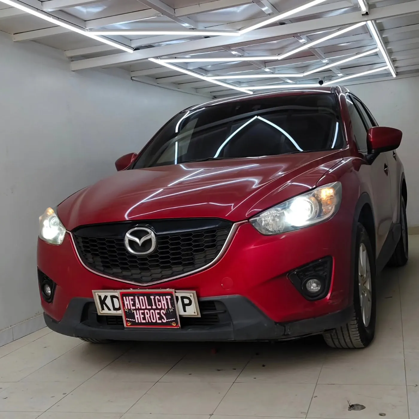 Red Mazda CX-5 in the bay with upgraded headlights on