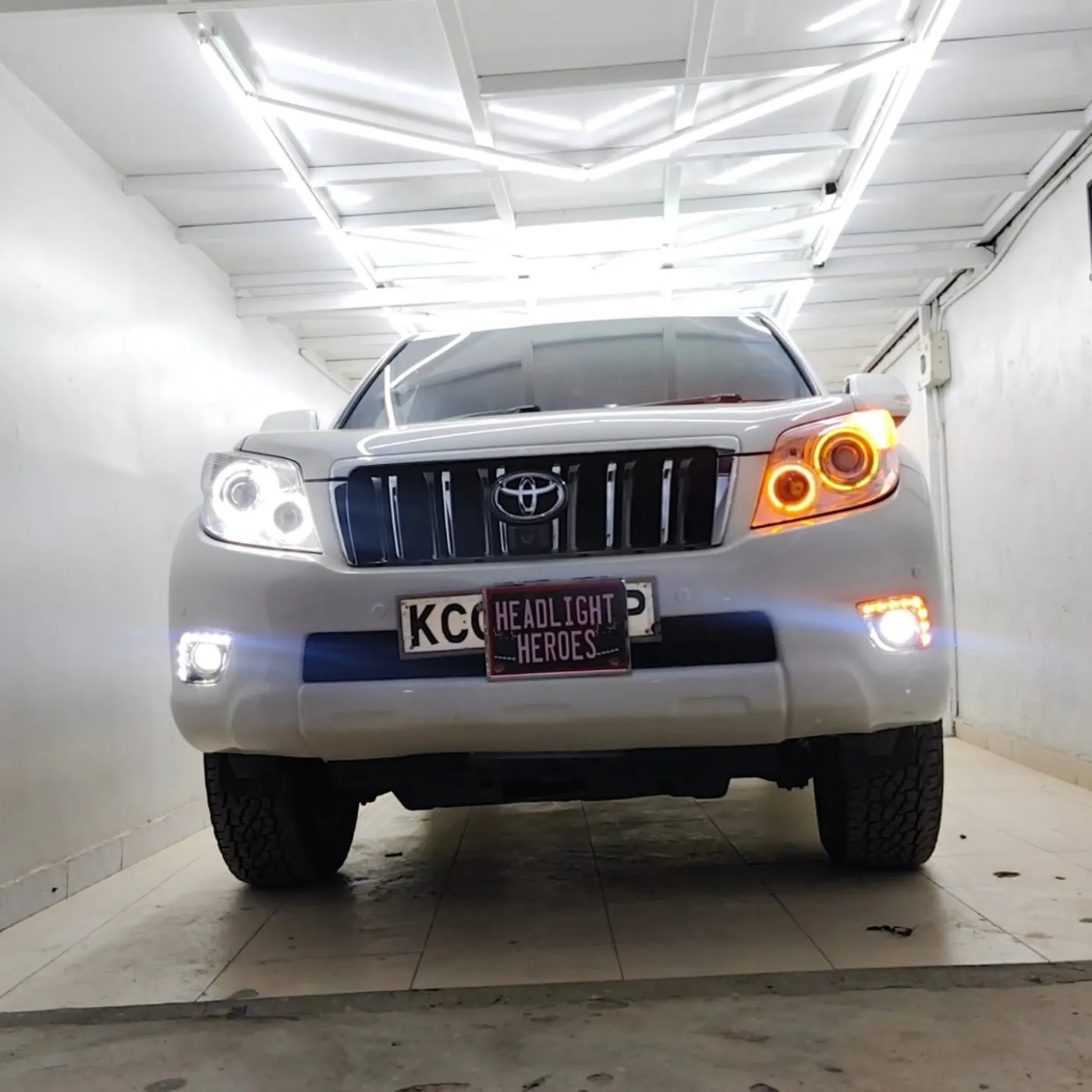 White Toyota Prado with amber running lights